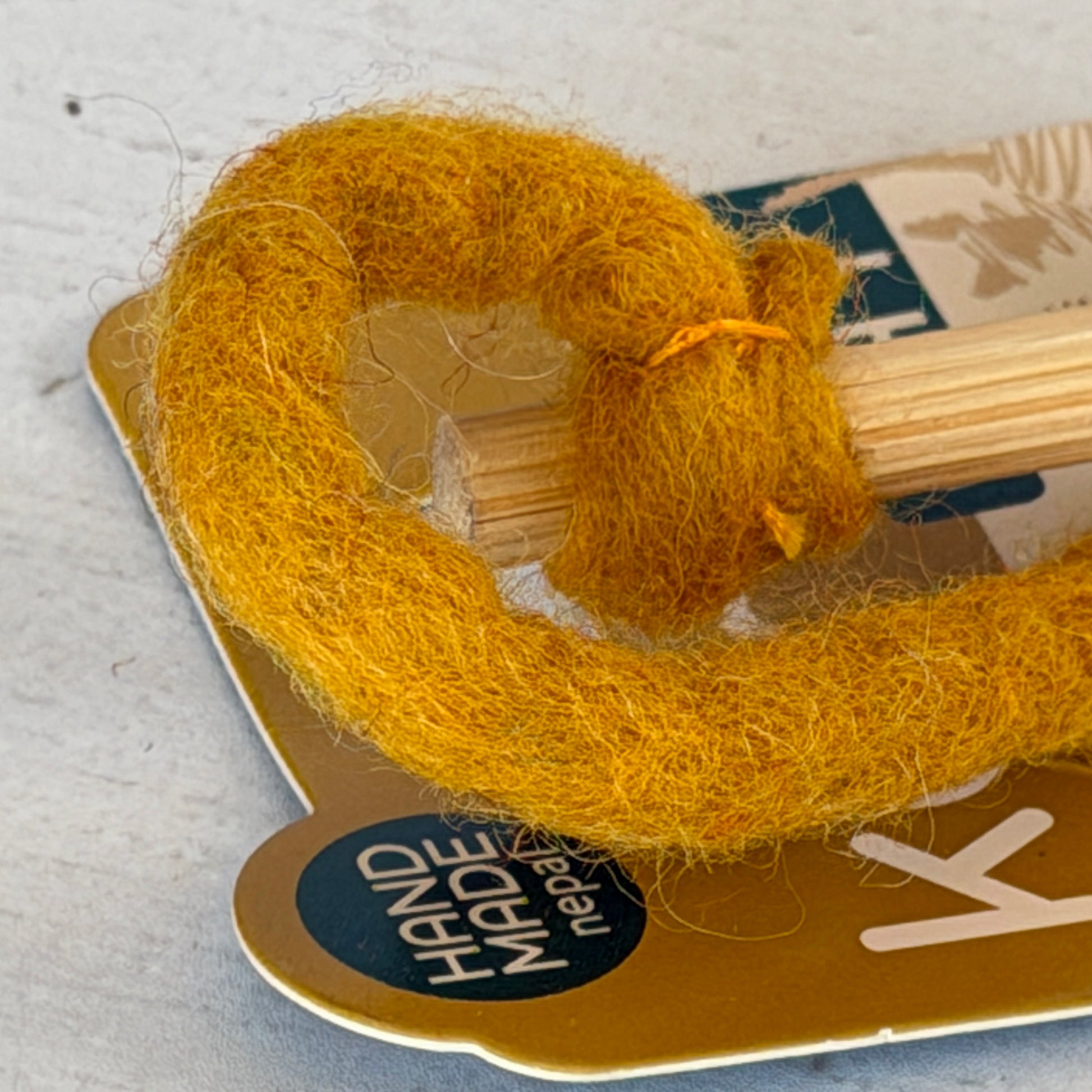 接着剤やワイヤーを使わず、フェルトを持ち手に結び付けています